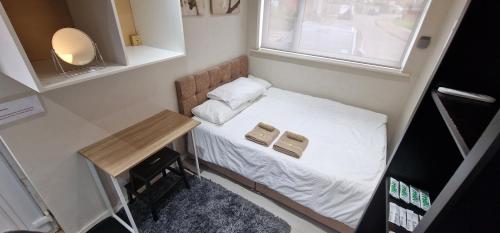 a small bed in a small room with a window at Oleon Apartments - Colchester in Colchester