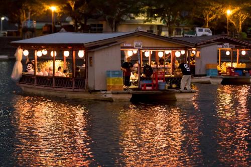 a boat with a restaurant on the water at night at Hita Onsen Kizantei Hotel in Hita