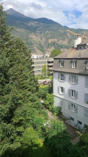 an apartment building in a city with a mountain at HEART Studio Visp Zentrum I ruhig I Single I Paare I Küche in Visp