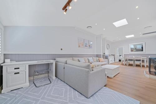 a living room with a couch and a table at Lakefront House - INEA Retreat in Karraganbah