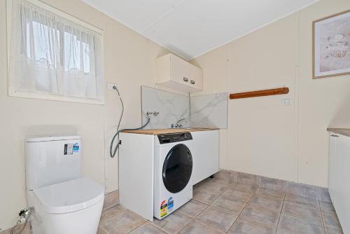 a laundry room with a washing machine and a washer at Lakefront House - INEA Retreat in Karraganbah