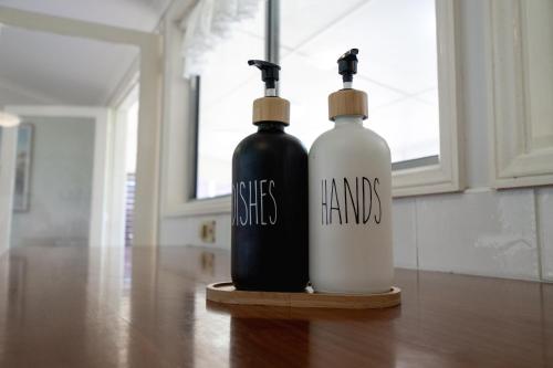 two black and white bottles sitting on a table at Lakefront House - INEA Retreat in Karraganbah
