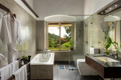 a bathroom with a tub and a sink and a toilet at Simpson's Forest - Luxury Boutique Resort & Spa - Kandy in Kandy