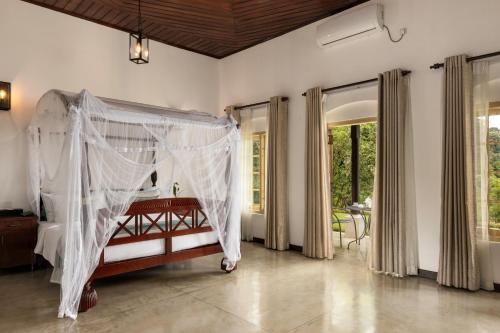 a bedroom with a bed with a mosquito net at Simpson's Forest - Luxury Boutique Resort & Spa - Kandy in Kandy