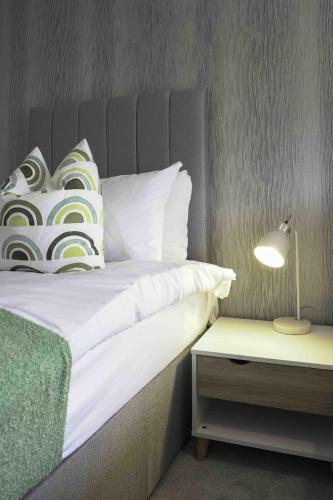 a bedroom with a bed with a lamp and a side table at Granby House in Livingston