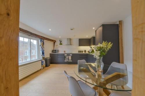 a dining room with a glass table and chairs at Luxury Character Apartment St Albans By Central Stays Short Lets & Serviced Accommodation With Free Parking in St. Albans