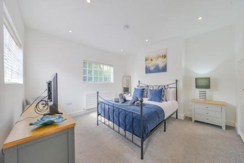 セント・オールバンズにあるLuxury Character Apartment St Albans By Central Stays Short Lets & Serviced Accommodation With Free Parkingのベッドとテレビ付きの机のある寝室