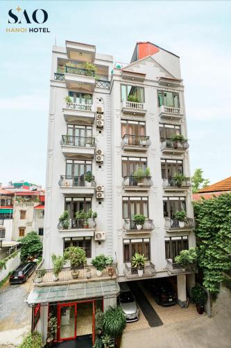 a white building with potted plants on it at Khách Sạn Sao in Hanoi