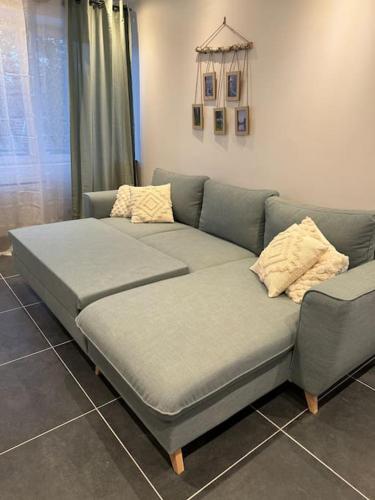 - un canapé avec deux oreillers dans le salon dans l'établissement Chez Julo, à Coulogne