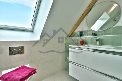 une salle de bain avec un lavabo et un miroir dans l'établissement LocaLise - M14 - Caligourdaine - Maison d'exception - Construction de 2024 - à 30m de la mer et quelques pas des plages - extérieur clos - 4 places de parking privatives - wifi inclus - draps inclus - centre et port à 7 minutes à pied, au Guilvinec