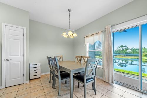 a dining room with a table and chairs and a window at Romar Lakes 104B in Orange Beach