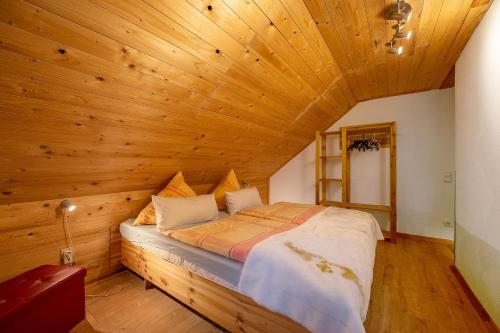 ein Schlafzimmer mit einem Bett in einer Holzdecke in der Unterkunft Ferienhaus Störzel - Wohnung B in Hundheim