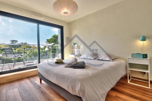une chambre avec un grand lit et une grande fenêtre dans l'établissement LocaLise - M14 - Caligourdaine - Maison d'exception - Construction de 2024 - à 30m de la mer et quelques pas des plages - extérieur clos - 4 places de parking privatives - wifi inclus - draps inclus - centre et port à 7 minutes à pied, au Guilvinec