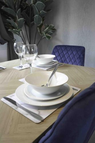 a wooden table with plates and wine glasses on it at Granby House in Livingston