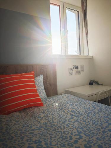 a bedroom with a bed with a pillow and a window at homecoming in Rīga