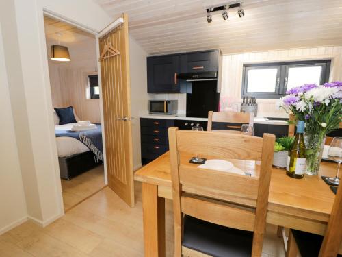 ルシンにあるEnia Lodge 2のキッチン、ダイニングルーム(テーブル付)、ベッドルーム1室が備わります。