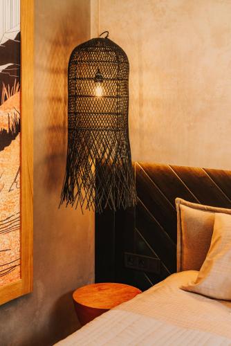 a bedroom with a bed and a black chandelier at Apartament Riders Lodge Sopot in Sopot