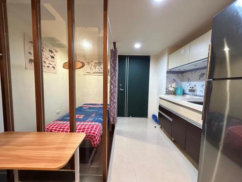 a small kitchen with a table and a refrigerator at Rihe Hot spring B&B in Jiaoxi
