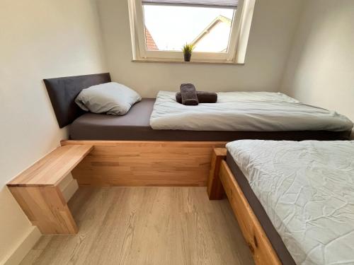 two beds in a small room with a window at Appartementhaus Schlagstein App2 in Kreuzau