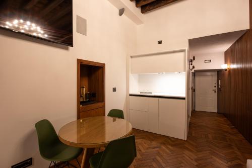 a kitchen with a table and green chairs in a room at Genova Centro - Lussuosa Suite Arte e Storia in Genova