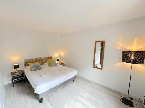 - une chambre avec un lit blanc et deux lampes dans l'établissement charmant T2, à Annecy