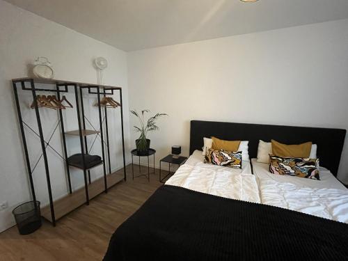een slaapkamer met een bed en een plank met kussens bij Bayreuth Apart No 7 in Bayreuth
