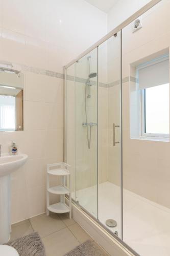 a bathroom with a glass shower with a sink at 2 minutes walk to JR & Manor Hospitals , Close to Oxford Brookes University Bluebird Apartment in Oxford