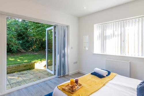 a bedroom with a bed and a large window at 2 minutes walk to JR & Manor Hospitals , Close to Oxford Brookes University Bluebird Apartment in Oxford