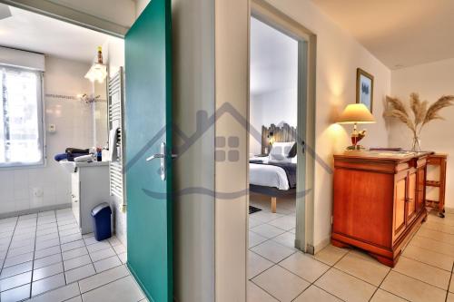 a room with a bed and a door leading to a bedroom at LocaLise - A02 - Appartement de plain-pied - terrasse - Juste à côté de la plage - Centre et port à pied - Wifi inclus - Draps inclus - Animaux bienvenus in Tréffiagat