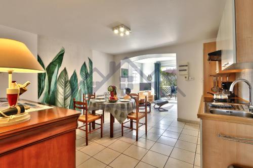 une cuisine et une salle à manger avec une table et des chaises dans l'établissement LocaLise - A02 - Appartement de plain-pied - terrasse - Juste à côté de la plage - Centre et port à pied - Wifi inclus - Draps inclus - Animaux bienvenus, à Tréffiagat