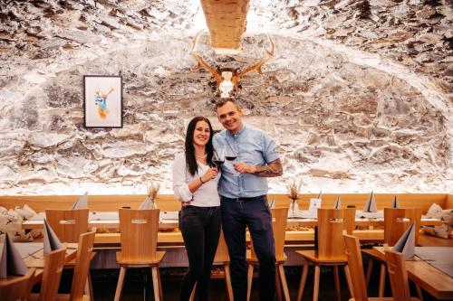 a man and a woman standing in a room with a glass of wine at Landgasthof Hirschen in Hohenems