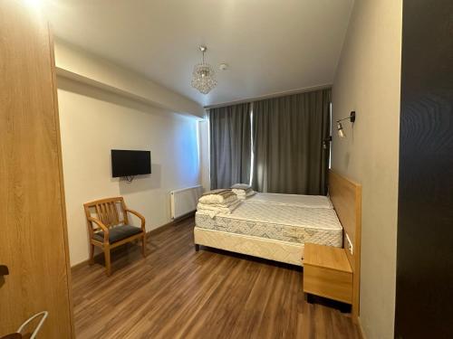 バクリアニにあるBakuriani Inn - Triple Lux #332のベッドと椅子のある小さな寝室