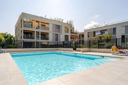 une piscine devant un immeuble dans l'établissement Newly Built Apartment with Pool, Walk to the Beach, à Antibes