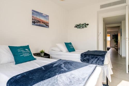 - 2 lits dans une chambre blanche avec des oreillers bleus dans l'établissement Newly Built Apartment with Pool, Walk to the Beach, à Antibes