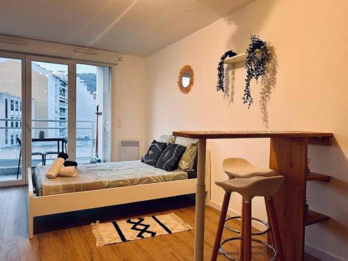- une chambre avec un lit et une table avec un tabouret dans l'établissement City & Serenity - Studio Proche Gare, à Nice