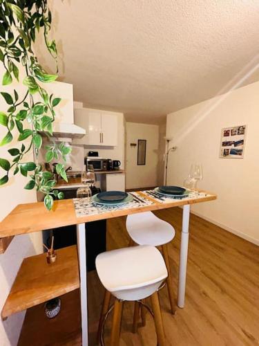 - une cuisine avec une table et deux tabourets dans une pièce dans l'établissement City & Serenity - Studio Proche Gare, à Nice