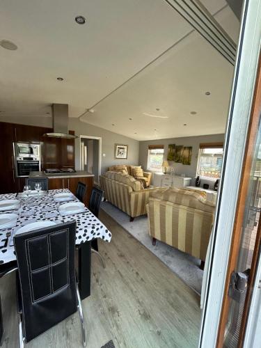 eine Küche und ein Wohnzimmer mit einem Tisch und einem Sofa in der Unterkunft The Lodge in Congleton