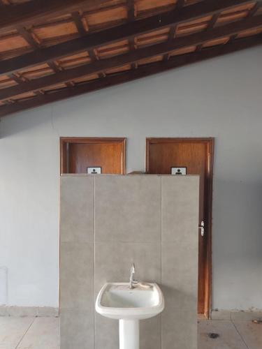 a bathroom with a white sink in a room at Casa mana in Olímpia