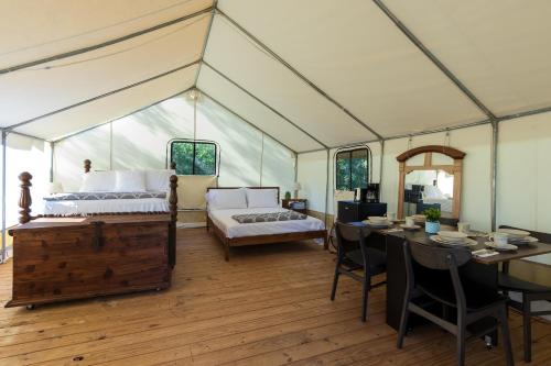 a room with a bed and a table in a tent at Khushatta Hills Ranch Glamping - Mom Mollie in Coldspring
