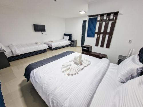 a room with two beds with white towels on them at Hotel Oaza in Kikinda