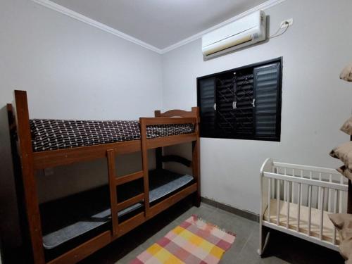a room with two bunk beds and a crib at Casa mana in Olímpia