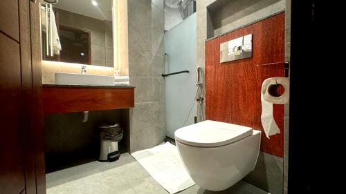 a bathroom with a white toilet and a sink at Baa Sand Maldives in Kudarikilu