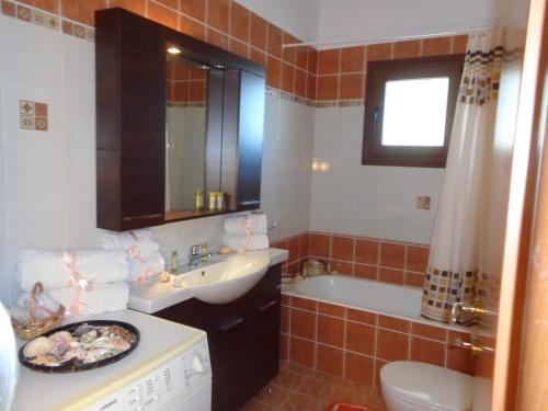 a bathroom with a sink and a bath tub at Villa Kiki in Lakhania
