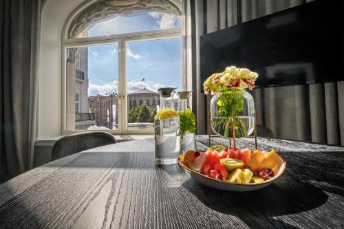 a bowl of fruit on a table in front of a window at Karl Johan Hotel in Oslo