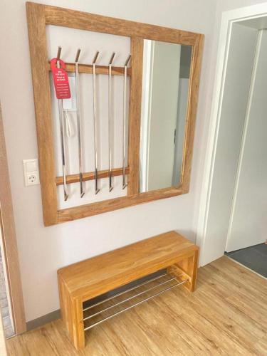 a mirror hanging on a wall with a wooden bench at Motel Q- das kleine Stadthotel in Dingolfing