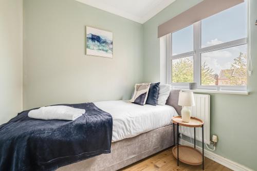 a bedroom with a bed and a window at Modern & Comfortable with Free Parking in Bedford