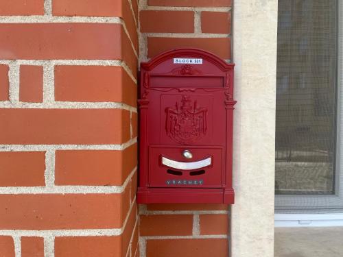 a red post box on the side of a brick wall at BLOCK 531 ApartHouse BLOCK 533 in Sofia