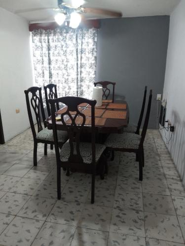 ein Esszimmer mit Tisch und Stühlen und einem Fenster in der Unterkunft Departamento in Villahermosa
