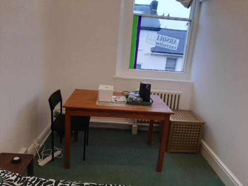 a small room with a wooden table and a window at Newport Ensuite Sleeps 2 near Train Station in Newport