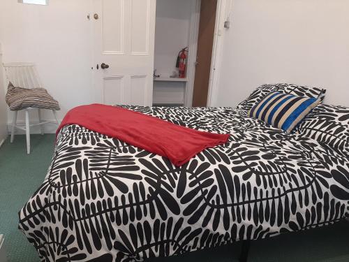 a bed with a black and white comforter on it at Newport Ensuite Sleeps 2 near Train Station in Newport